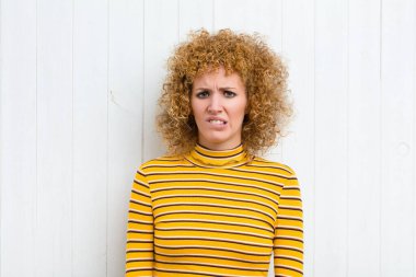 Genç ve güzel bir kadın kafası karışık ve kuşkulu, merak ediyor ya da karar vermeye çalışıyor.