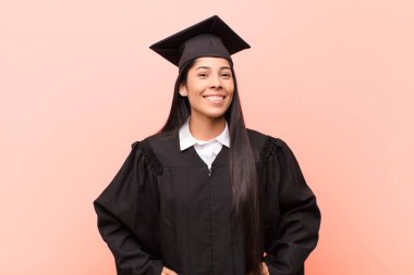 Genç Latin kız öğrenci neşeli ve gelişigüzel gülümsüyor pozitif, mutlu, kendinden emin ve rahat bir ifadeyle.