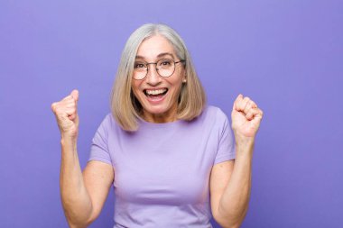 Yaşlı ya da orta yaşlı güzel bir kadın şok olmuş, heyecanlı ve mutlu hissediyor, gülüyor ve başarıyı kutluyor.!