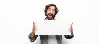 Genç, çılgın, havalı adam beyaz duvara karşı bir pankart tutuyor.