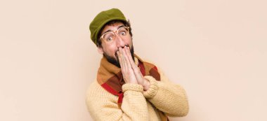 Genç, havalı sakallı adam mutlu ve heyecanlı, şaşırmış ve hayrete düşmüş ağızları ellerle kaplayan, tatlı bir ifadeyle kıkıran