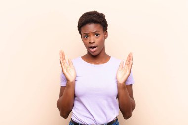 Genç, güzel, siyah bir kadın. Şaşırmış ve şaşkın görünüyor. İnanılmaz bir şey fark edince, ağzı açık kalıyor.