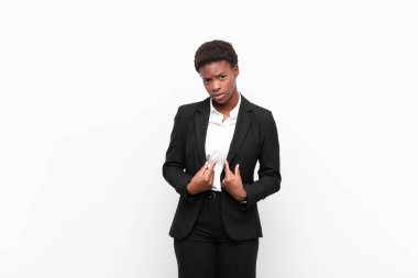 Kafası karışık ve tuhaf bakışlarıyla kendini gösteren genç, güzel siyahi kadın beyaz duvara karşı seçildiği için şaşırmış ve şaşırmıştı.