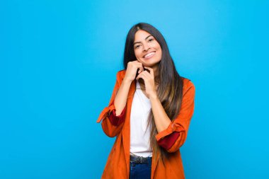 Genç, güzel, Latin bir kadın aşık ve sevimli görünüyor. Sevimli, sevimli ve mutlu. Romantik bir şekilde gülümsüyor.