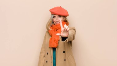 Yaşlı ya da orta yaşlı güzel bir kadın gururla gülümsüyor ve bir numaralı pozu başarıyla veriyor, kendini lider gibi hissediyor.