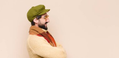 Genç, havalı sakallı adam kolları bağlı mutlu, gururlu ve tatmin olmuş bir adam gibi görünüyor.