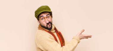 Genç havalı sakallı adam kafası karışık ve bilgisiz, şüpheli bir açıklama ya da düşünceyi merak ediyor.