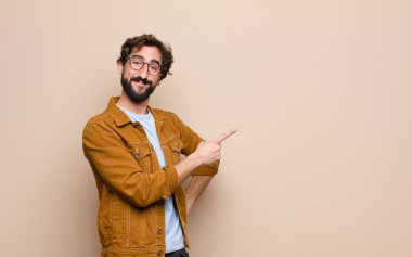 Genç, havalı ve çılgın adam yassı duvara yaslanmış.