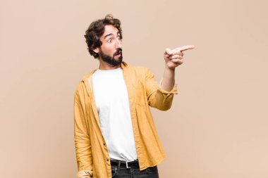 Genç, çılgın, havalı adam şok olmuş ve şaşırmış hissediyor. Şaşırmış ve yukarı bakıyor. Şaşırmış, ağzı açık bir şekilde duvara bakıyor.