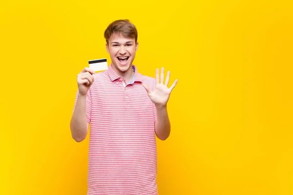 Joven Hombre Rubio Con Una Tarjeta Crédito —  Fotos de Stock