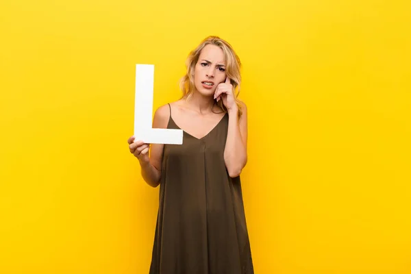 Young Blonde Woman Confused Doubtful Thinking Holding Letter Alphabet Form — Stock Photo, Image