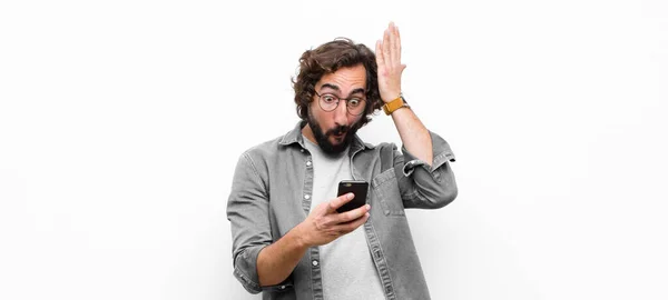 Genç Çılgın Adam Akıllı Telefonunu Beyaz Duvara Karşı Kullanıyor — Stok fotoğraf