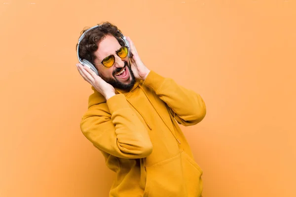 Ung Galen Cool Man Lyssnar Musik Med Hörlurar Mot Orange — Stockfoto