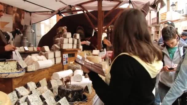 Nő vásárol sajt az utcai piac: a történelmi központ Montblanc, Spanyolország. — Stock videók