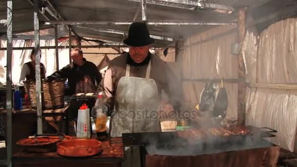 Mensen koken vlees en worstjes op de brand in de straat tijdens de middeleeuwse festival in Montblanc, Spanje. — Stockvideo