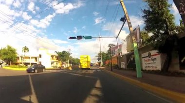 Puerto Plata, Dominik Cumhuriyeti için asfalt karayolu ile sürüş araba sarı Turist otobüsü görüntülemek. 