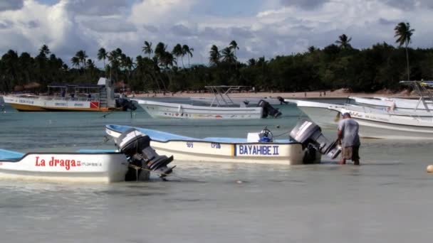Mann repariert Bootsmotor im Hafen von Bayahibe, Dominikanische Republik. — Stockvideo