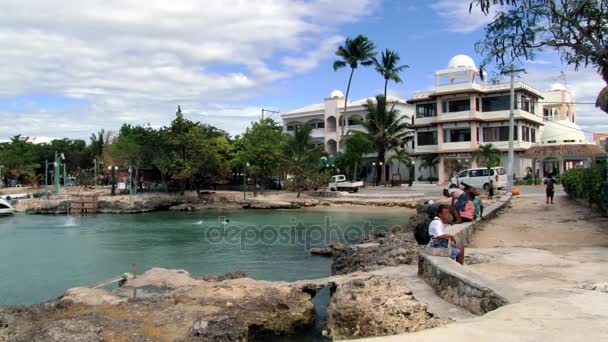 People relax at the harbor of Bayahibe town in Bayahibe, Dominican Republic. — Stock Video