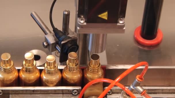 Flakony přesunout, uzavírá na výrobní lince v továrně parfémy Fragonard v Grasse, Francie. — Stock video