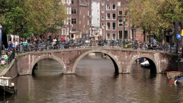 Mensen lopen door de brug over kanaal in Amsterdam, Nederland. — Stockvideo