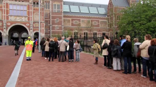 Люди чекати в черзі, щоб відвідати Державного музею в Амстердамі, Нідерланди. — стокове відео
