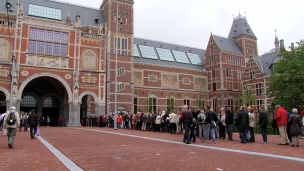 Lidé čekat ve frontě na návštěvu muzea Rijksmuseum v Amsterdamu, Nizozemsko. — Stock video