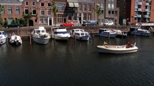 La gente pasa por el canal con el barco en Delfshaven en Rotterdam, Países Bajos . — Vídeo de stock