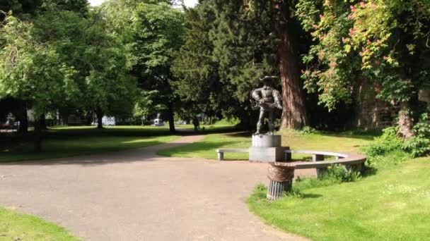 Herr fährt Fahrrad im Aldenhofpark vor der Statue des Dartagnan in Maastricht, Niederlande. — Stockvideo