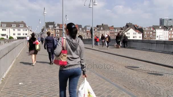 Menschen gehen an der mittelalterlichen Heilig-Servatius-Brücke in Maastricht, Niederlande. — Stockvideo