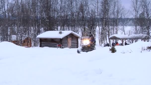 Ο άνθρωπος βόλτες με snowmobile στην τοπική εκκλησία στο Inari, Φινλανδία. — Αρχείο Βίντεο