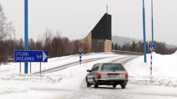 Auto passiert Kreuzung an der Eisstraße in der arktischen Stadt Ivalo, Finnland. — Stockvideo