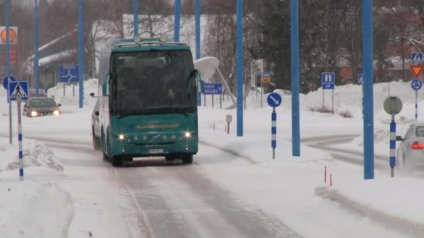 Ônibus turísticos passam pela estrada coberta de gelo e neve na cidade ártica de Ivalo, Finlândia . — Vídeo de Stock