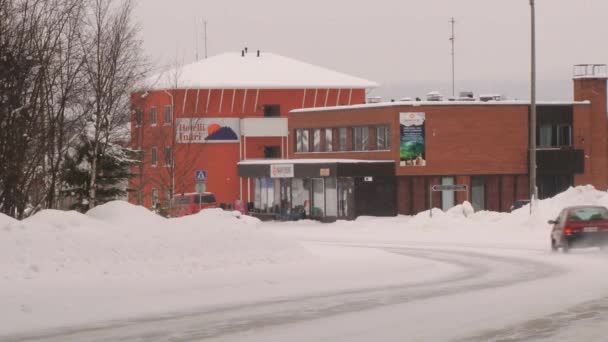 El coche pasa por la carretera frente al hotel Inari en Inari, Finlandia . — Vídeos de Stock