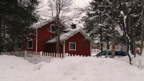 Met het oog op een typische houten rood geschilderde Finse huis in de winter in Inari, Finland. — Stockvideo