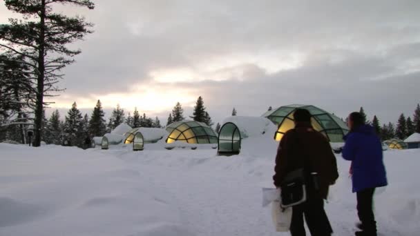 Los turistas llegan a las originales habitaciones de hotel construidas como iglús de cristal en Saariselka, Finlandia . — Vídeos de Stock