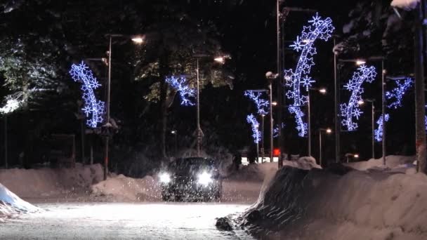 Car passes by the street with Christmas decorations at night in Saariselka, Finland. — Stock Video