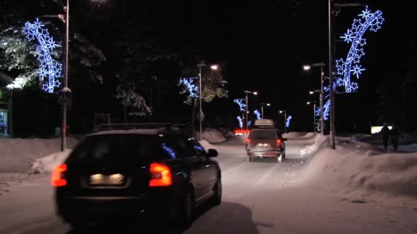 Autos fahren nachts mit Weihnachtsschmuck auf der Straße in Saariselka, Finnland. — Stockvideo