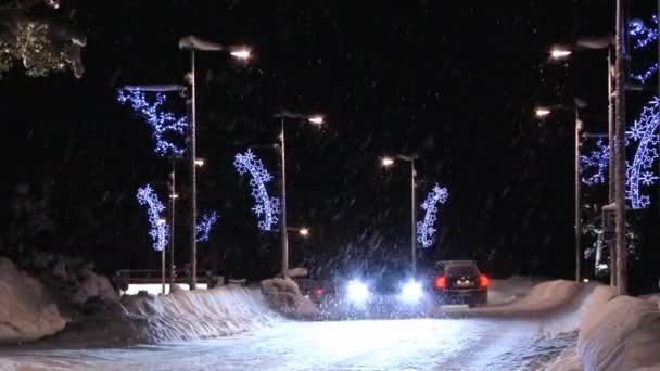 汽车路过街与圣诞装饰品在萨里塞尔卡，芬兰的夜晚. — 图库视频影像