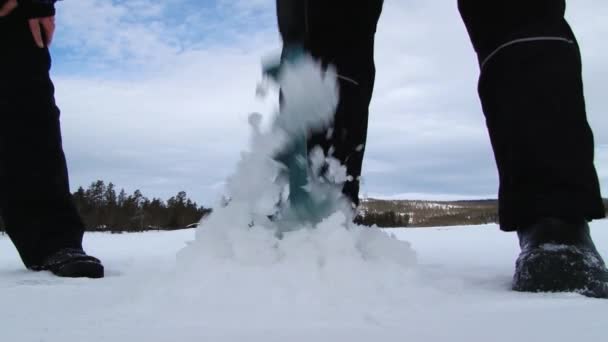 Άνθρωποι τρυπάνι τρύπα στον πάγο για την αλιεία στον πάγο στη λίμνη σε Trysil, Νορβηγία — Αρχείο Βίντεο
