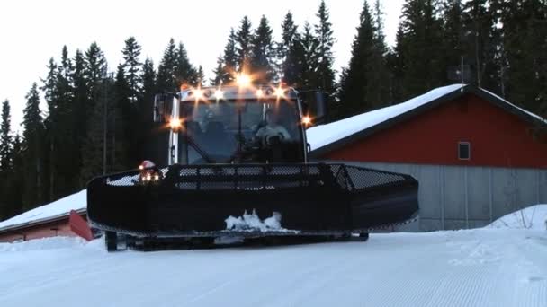Förare ta röd snowcat maskiner ur garaget till skidbackarna i Trysil, Norge. — Stockvideo