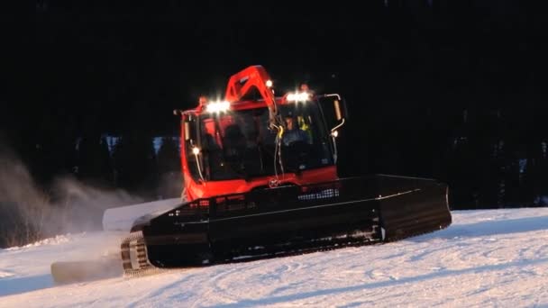 Människor driva snowcat maskiner förbereder skidbackarna vid solnedgången i Trysil, Norge. — Stockvideo