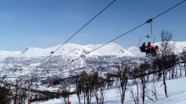Lidé se stěhují do kopce s sedačkové lanovky v lyžařském středisku ve městě Hemsedal, Norsko. — Stock video
