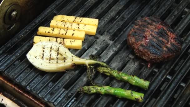 Biff som tilberedes med løk, ost og asparges på grillen . – stockvideo