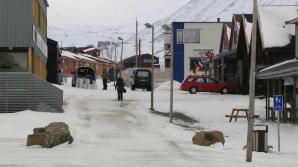 Mensen lopen door de straat van de Arctische stad van Longyearbyen, Noorwegen. — Stockvideo