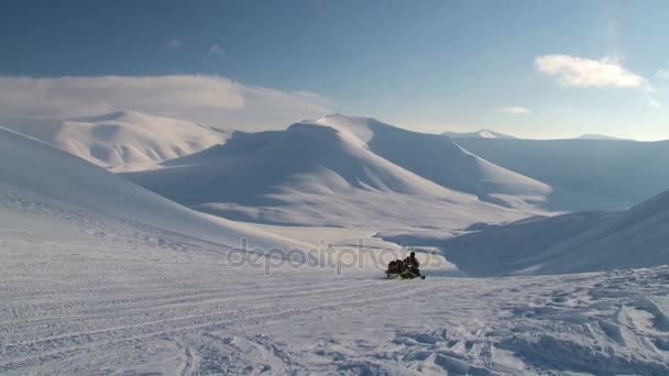 Люди ездят на снегоходах в горах архипелага Шпицберген (Шпицберген) недалеко от города Лонгйирбиен, Норвегия . — стоковое видео