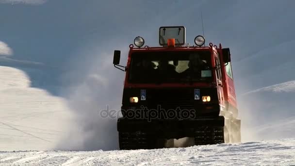 La gente guida il veicolo rosso del gatto delle nevi sulla neve artica nelle montagne dell'arcipelago di Spitsbergen (Svalbard) vicino alla città di Longyearbyen, Norvegia . — Video Stock