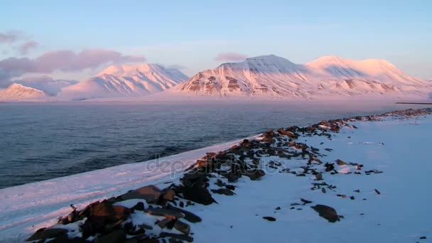 Melihat ke pantai laut Arktik dan pegunungan di kepulauan Spitsbergen (Svalbard) saat matahari terbenam pada musim semi dekat Longyearbyen, Norwegia . — Stok Video