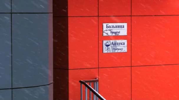 Exterior detail of the modern hospital building with signs in Russian and English in the Russian arctic settlement Barentsburg, Norway. — Stock Video