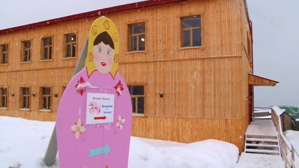 Exterior de los edificios con el cartel que dirige al restaurante y cervecería en el asentamiento ártico ruso Barentsburg, Noruega . — Vídeo de stock