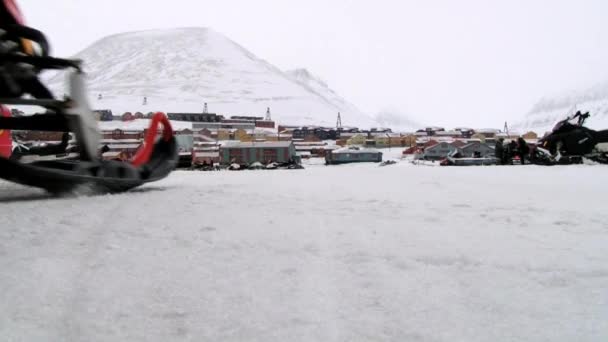 Man rides snowmobile in the arctic settlement of Longyearbyen, Norway. — Stock Video